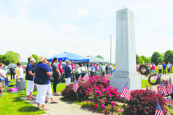 The assembled crowd at Locust Grove Cemetery gather around the Veterans Monument and join together in the Pledge of Allegiance.