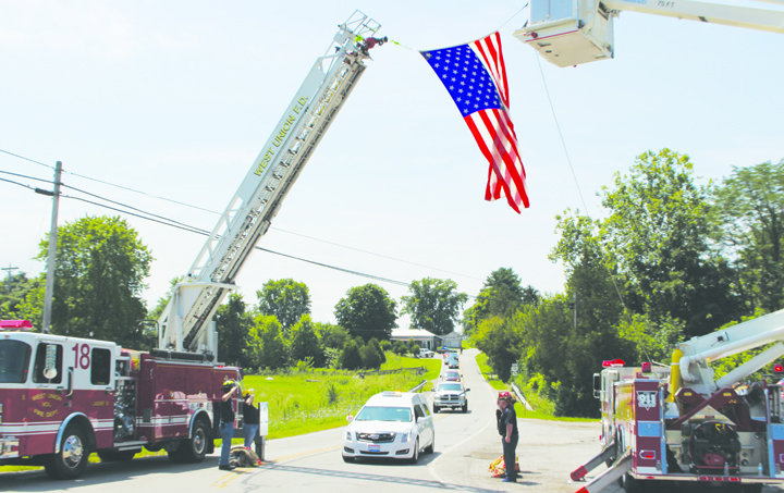 The funeral procession for Franklin Township firefighter Billy Purtee passes under the arch created by West Union and Mt. Orab Fire Departments.