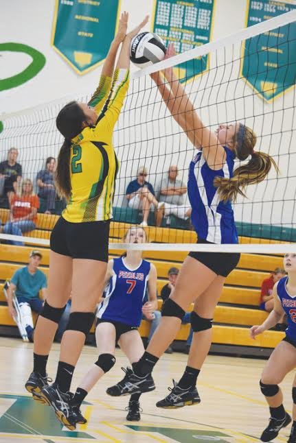 West Union’s Houston Adkins, left, battles at the net with Peebles’ Madison Pierce during action from last week’s match at West Union High School.