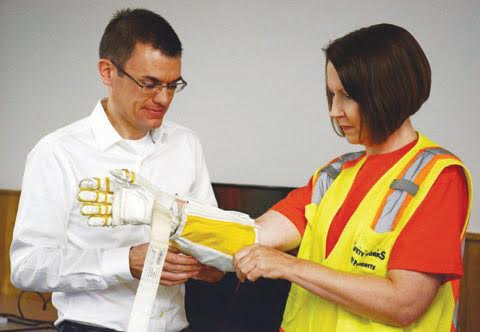 Kimberly Browning of Peebles, right, is fitted with the NASA RoboGlove, as part of the “Science of Safety” workshops.