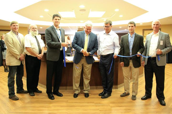 Adams County Commissioner Ty Pell, center, handles the ribbon-cutting duties at Tuesday’s grand opening ceremonies for the new Monarch Meadows facility in Seaman.