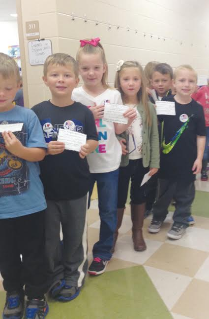 Pictured here are kindergarten students from Mrs. Karisa Miller's kindergarten class. These students had just voted and are showing their identification card and voter sticker.