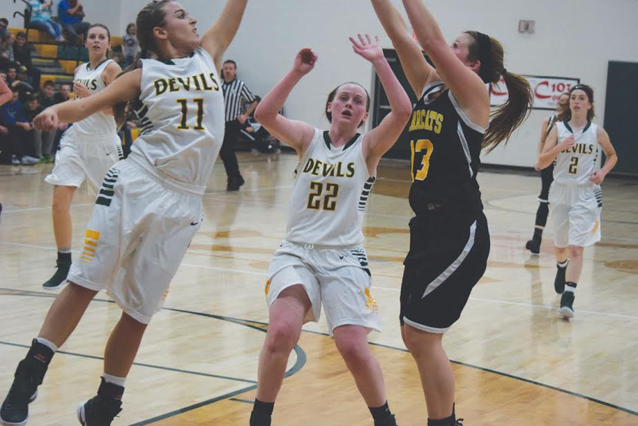 North Adams’ Lakyn Hupp (11) and Grace McDowell (22) converge on a Paint Valley shooter in action from Tuesday night’s varsity contest. Hupp and McDowell combined for 32 points as the Lady Devils won their season opener by a final score of 56-32