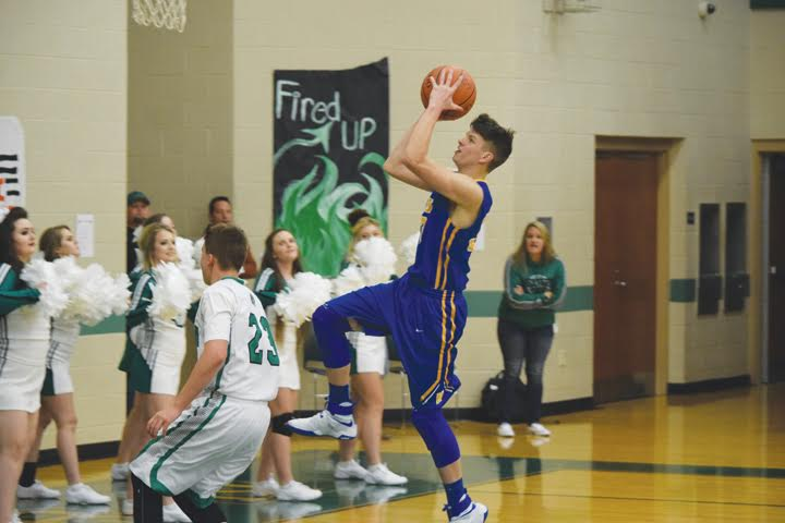 Manchester’s Kaulen Cox goes over a Western defender and to the rim during first half action of last Friday’s varsity boys basketball contest. Cox led the Hounds with 17 points, all in the first half, as Manchester let a big lead slip away and fell in their season opener 59-54.