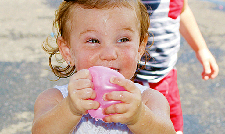 On a warm AEP Family Day, water balloons were a welcome sight for the young people, and this young lady certainly seems to be enjoying hers