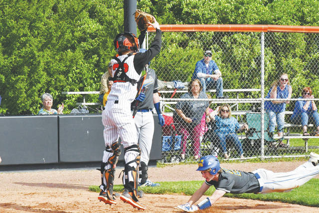 <p>Manchester’s Ryland Wikoff, right, slides home safely with a first-inning run in the Hounds’ 6-3 win at Whiteoak on May 18. (Photo by Mark Carpenter)</p>