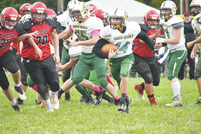 North Adams freshman running back Camden Huff looks for running room around the edge on the muddy field in Seaman during the Devils 30-20 win over Southern Buckeye on Oct. 30. (Photo by Mark Carpenter)