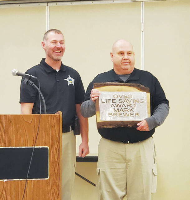 Mike Parker stands with Mark Brewer (right) as he proudly displays his award. (Photo by Ashley McCarty)