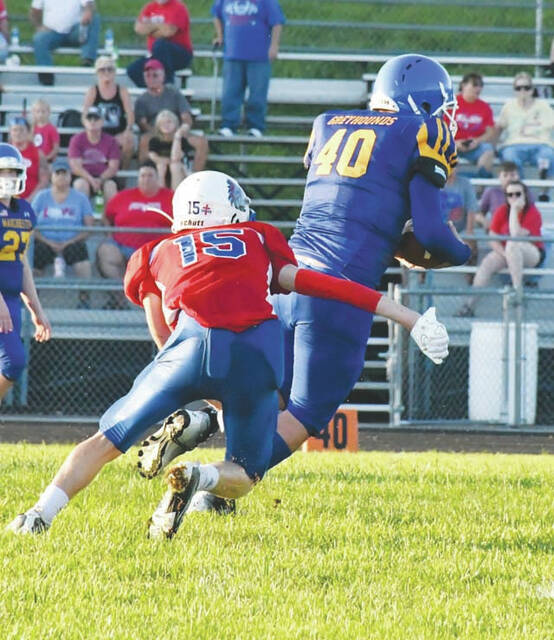 <p>After hauling in a pass, Manchester tight end Logan Neria (40) is hauled down by Peebles defender Sol Beech-Turner, (Photo by Mark Carpenter)</p>