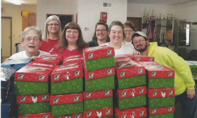 2021 Shoebox Crew with a new stack of shoeboxes to be loaded into large shipping boxes. Front Row, from left, Sara Lewis, Marjorie Swearingen, Sarene Bellamy and Sammy Thacker; Back Row, from left, Rhonda Moore, Area Coordinator, Angela Horvath, Adams County Coordinator, and Sheila Suiter, Central Drop Off Leader in Hillsboro. (Photo provided)