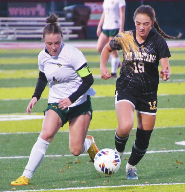 North Adams senior Olivia Wright, left, races Lynchburgs Addie Downing down the sideline as the two teams battled on November 1 in a Division III regionals semi-final match up. (Photo by Mark Carpenter)