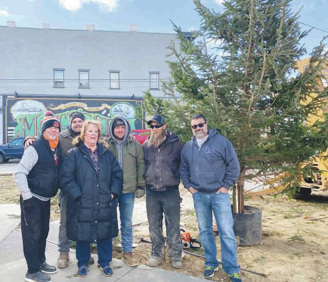 Councilwoman Christina Henderson, with her band of merry helpers, posing by the Christmas Tree donated by MoonDoggie LiVerEE.