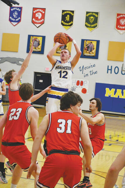 Manchesters Connor Darnell (12) rises above the crowd to get off a jump shot in action from the Greyhounds 60-49 loss to Fairfield. Darnell led Manchester with 14 points. (Photo by Mark Carpenter)