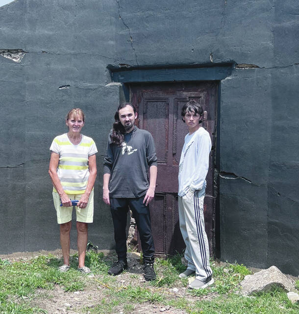 Patsy, Zachary, and Zane Roberts standing in front of the Crypt at the Winchester Cemetery. (Photo by Sherry Larson)