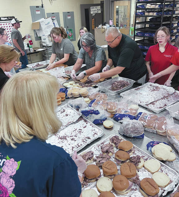 Volunteers work hard to prepare and distribute the meals at the Junior Fair BBQ. (Photo by Sherry Larson)