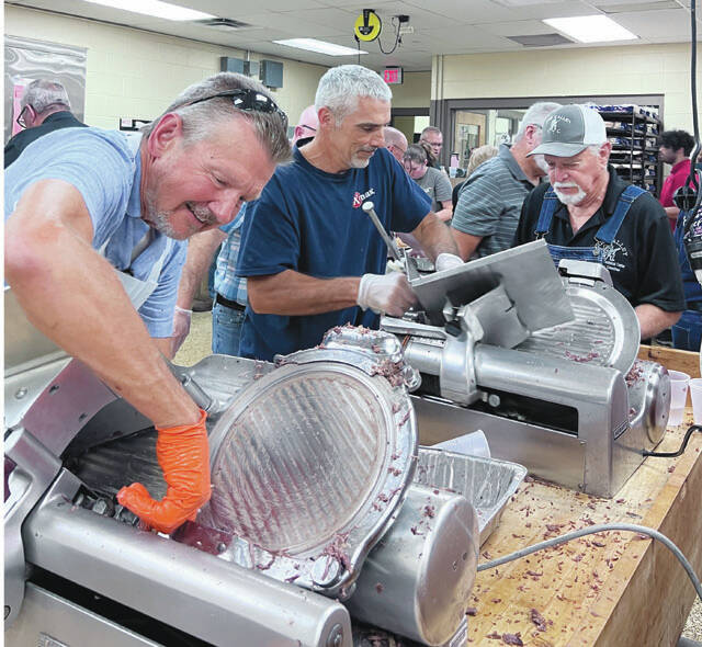 Slicing the meat at this years Junior Fair BBQ. (Photo by Sherry Larson)