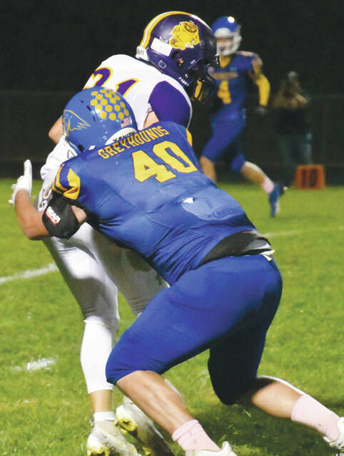 Manchesters Logan Neria (40) wraps up a Southern runner in action from the Hounds 58-14 loss on their home field on October 13. (Photo by Mark Carpenter)