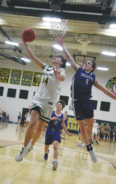 The typical result of the North Adams break is the layup, such as this one put in by junior Carson Osborne (14), over the outstretched arms of Chesapeakes Kaden Perkins (4). (Photo by Mark Carpenter)