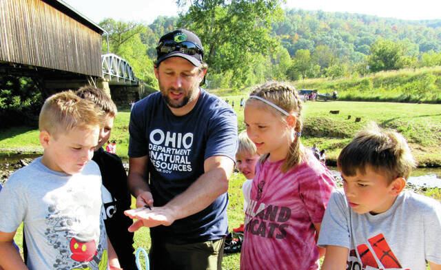 Bela Clutter of the Ohio Scenic Rivers Program assists local Northwest Middle School students at the 2023 Annual Scioto Brush Creek Day, near Otway.