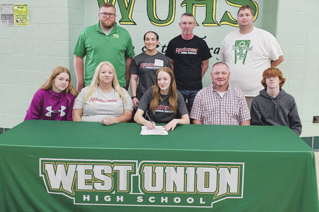 Present for the May signing ceremony were: Front row, from left, Lylah Adams (sister), Amber Adams (mother), Scotlyn Adams, Scott Adams (father) and Colten Adams (brother); Back row, from left, Ethan Stricklett (WUHS Athletic Director), Alexia Ward (Rio Womens Wrestling Coach), Michael Felts (WUHS Wrestling Coach) and Eric Sheldon (WUHS Assistant Wrestling Coach). (Photo by Mark Carpenter)
