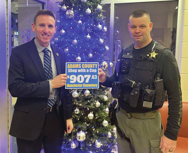 131169824_web1_ShopCop-1
Manchester Elementary School Principal Tate Skinner (left) presents Deputy SRO John Shope with $907.63 that was collected by MES students and donated to the Shop With A Cop program. (Photo provided by Manchester Elementary)