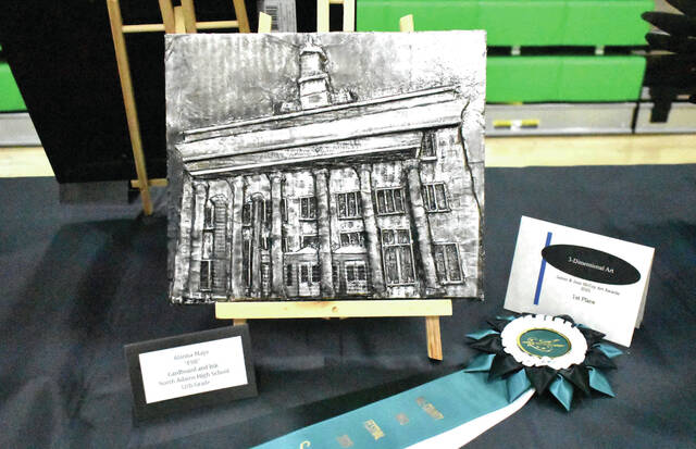 131390027_web1_All-County-Art
North Adams senior Alanna Mays was awarded first place in the 3-D category for the McCoy Art Award at the All County Arts and Music Festival on March 19 with her cardboard and ink relief titled FSB. (Photo by Ryan Applegate)