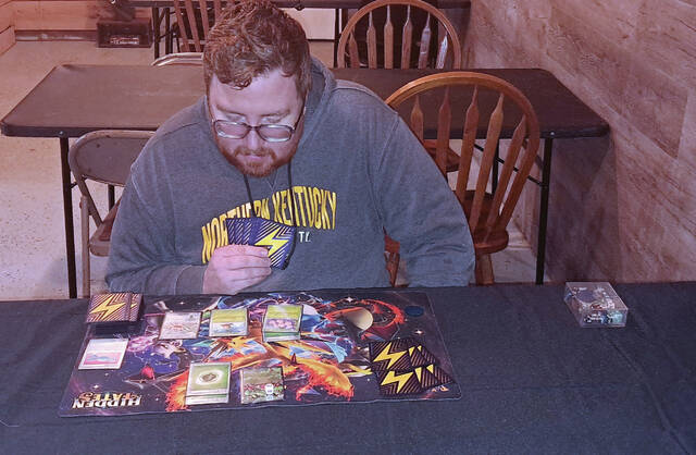 131406483_web1_Levi-Pertuset
Timbering Pines owner and organizing Pokemon Professor for Play! Pokemon League events Levi Pertuset studies his play mat and cards during a casual battle this week. (Photo by Ryan Applegate)