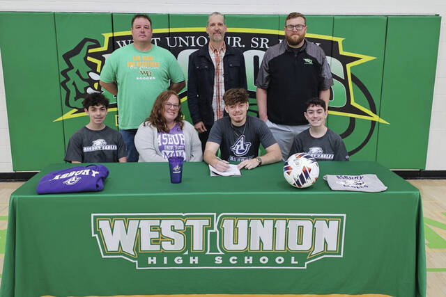 131488052_web1_SmithSigning
Pictured at the April 14 signing ceremony: Front row, from left, John Smith (brother), Mary Black-Smith (mother), James Smith and Jacob Smith (brother); Back row, from left, Silas Mills (WUHS Boys Soccer Coach), Tom Wuest (Former WUHS Boys Soccer Coach) and Ethan Stricklett (WIHS Athletic Director). (Photo by Mark Carpenter)