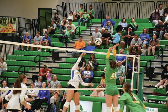 <p>Manchester’s Jocelyn Lucas (12) goes up for a kill attempt over the outstretched arms of West Union’s Shelbi Weakley as the two teams battled for five sets last week in SHAC action. (Photo by Mark Carpenter)</p>