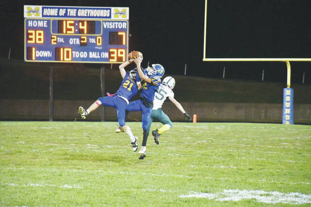<p>Manchester defenders Hunter Raines (21) and Amillion Brown (12) go high to break up a pass intended for North Adams’ Jackson Moore in the third quarter of last Friday night’s game at MHS. (Photo by Mark Carpenter)</p>