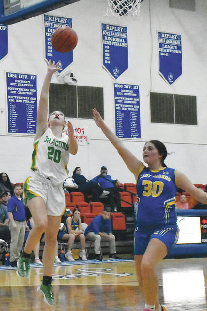 <p>West Union’s Maddie Stout (20) scores on a layup over Manchester’s Bella Hughes (30) as the two county squads faced off in the SHAC preview on November 14. (Photo by Mark Carpenter)</p>