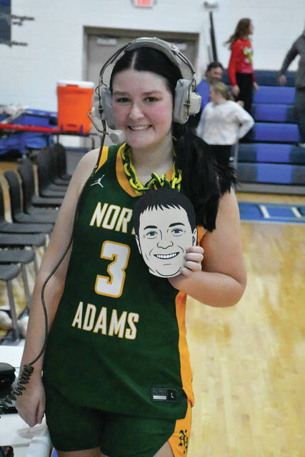 <p>During her postgame radio interview, North Adams sophomore Jacee Davis “reps” her father, Coach Rob Davis, after his 400th career victory at Ripley on December 11. (Photo by Mark Carpenter)</p>