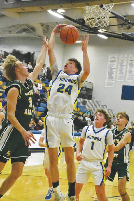 <p>Manchester’s Elijah Crabtree hauls in one of his five rebounds in the Greyhounds’ home loss last week to North Adams. (Photo by Mark Carpenter)</p>