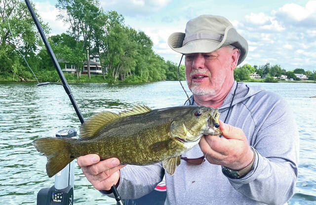 Tom Cross, shown here with anice smallmouth bass, is the Executice Director of the Adams County Travel and Visitors Bureau. But his true passion is hunting and fishing in his native southern Ohio.