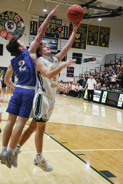 Senior Preston Call, right, avoids a Southeastern defender during the North Adams 61-53 district tournament victory. Call proovided a spark off the bench and scored 6 points in the win. (Photo by Mark Carpenter)
