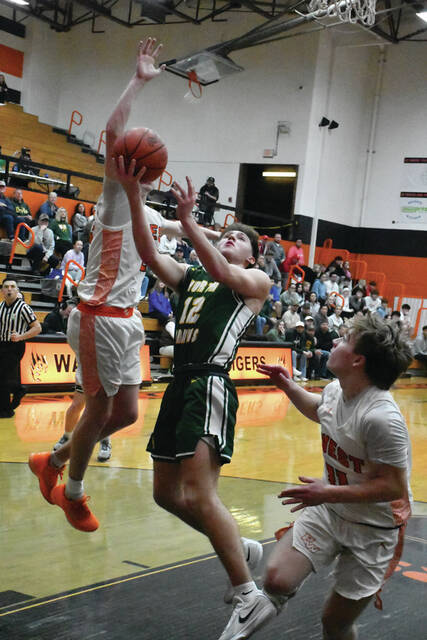 (North Adams senior Dalton Pence gets off a layup attempt in the Green Devils 54-39 season-ending defeat to Portsmouth West. (Photo by Mark Carpenter)