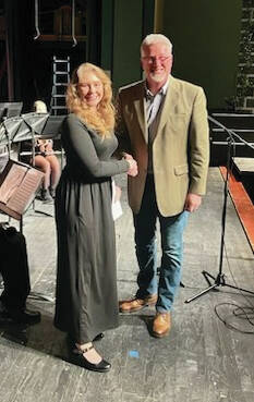 Nina McCann receives her Maggie Hoff Scholarship from Ken Smith during the annual All-County Arts & Music Festival. (Photo provided)