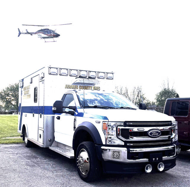 An Adams County EMS ambulance is pictured as an Air Evac helicopter flies overhead, highlighting the role of emergency responders across the county as voters consider a levy on the May 5 primary ballot to fund EMS services. (Submitted photo)