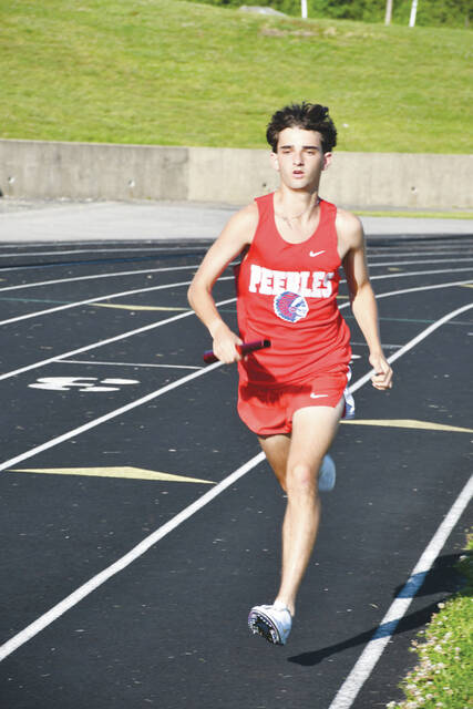 Peebles Grady Myers competes in one of the relay raced at the May 12 Southern Hills Athletic Conference Track meet in Manchester. Photo by Mark Carpenter)