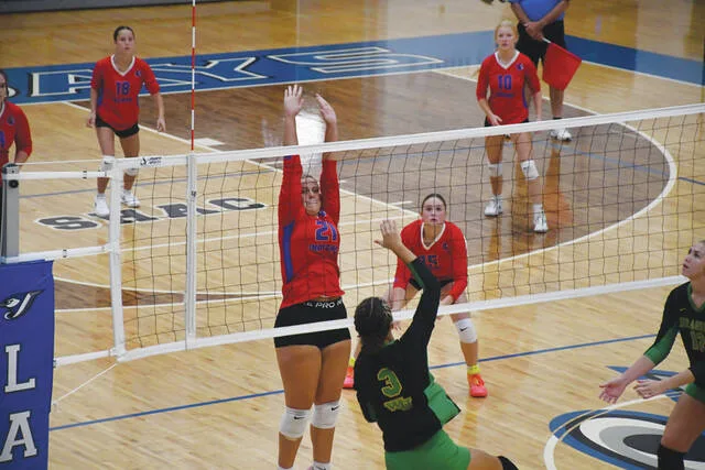 Peebles sophomore Alyssa Crabb (21) goes arms extended for the block attempt on West Unions Maddie Stout (3) as the two county teams faced each other in the SHAC Volleyball Preview. (Photo by Mark Carpenter)