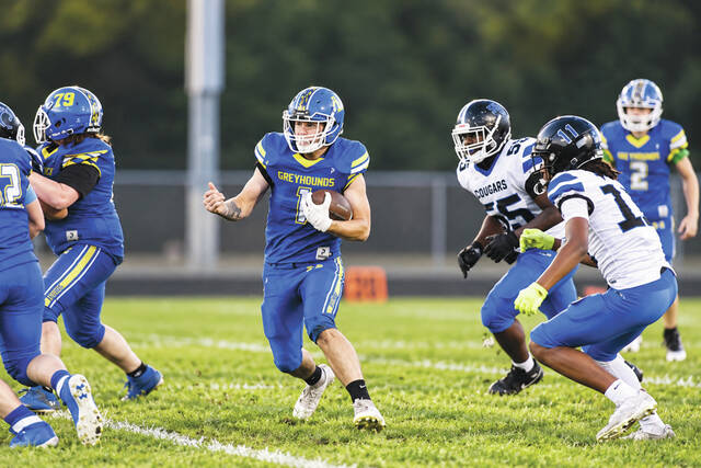 Before leaving the game with an injury, Manchester senior Dylon Fite finds a hole in the Clark Montessori defense in this first quarter carry. (Photo by Mark Carpenter)